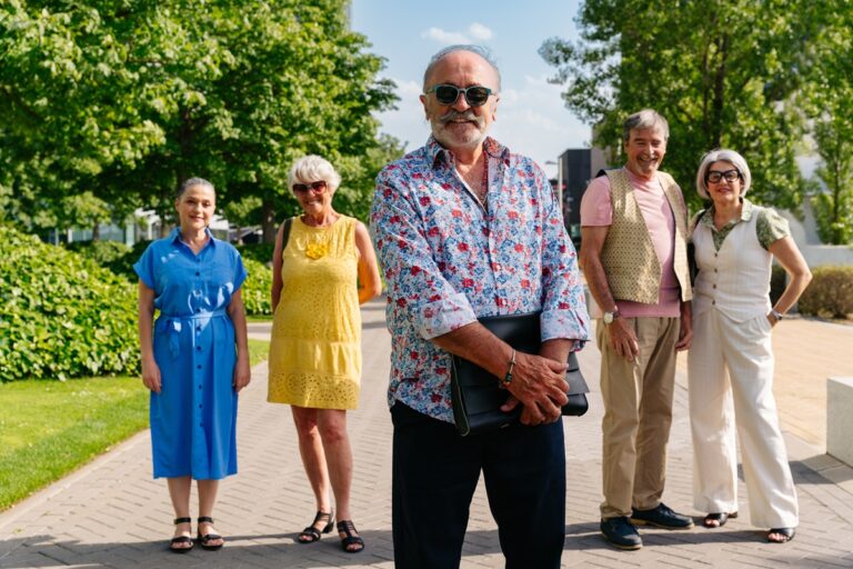 Szczęśliwi bezpieczni seniorzy na dworze przed domem seniora